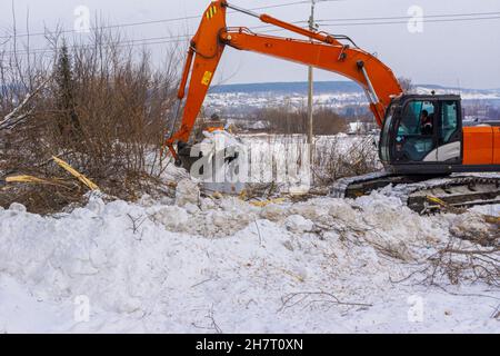 Vor Beginn der Bauarbeiten Schnee und Schmutz von der Baustelle entfernen Stockfoto