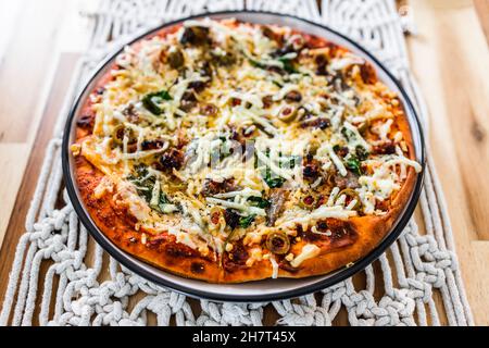 Vegane Pizza mit milchfreien Käsesoliven gerösteter Knoblauch und Spinat, gesunde pflanzliche Speiserezepte Stockfoto