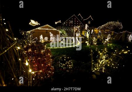 Balzhausen, Deutschland. 23rd. November 2021. Im Garten eines so genannten Weihnachtshauses leuchten ausgesägte Krippenfiguren, eingerahmt von Lichtern. Es dauerte vier Wochen, bis Josef Glogger das Haus und seinen Garten dekorierte. (To dpa bunt oder besinnlich - Weihnachtshäuser schaffen Adventsstimmung) Quelle: Karl-Josef Hildenbrand/dpa/Alamy Live News Stockfoto