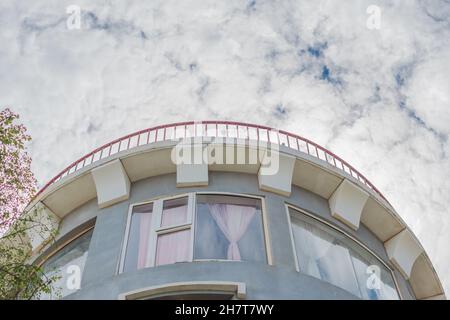 Bottom-up-Ansicht Beton grau modernen Himmel Turm Gebäude mittelalterliche Festung Burg Stil Rundes Dach ragen Backstein Metall Geländer großes Fenster. Ungewöhnlich Stockfoto