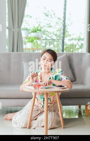 Lächelnde Rentnerin, die sich während der Quarantäne zu Hause entspannt Stockfoto