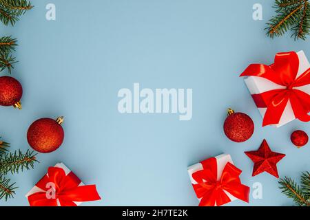 Weihnachtskomposition, Geschenke, Tannenzweige, rote Dekorationen auf blauem Hintergrund, Winter, Neujahr-Konzept. Flaches Lay, Kopierraum. Stockfoto