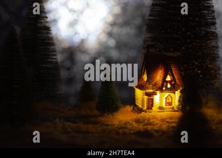 Spielzeug kleines Haus in den Wäldern in der Nacht, weihnachtsgeschichte Stockfoto