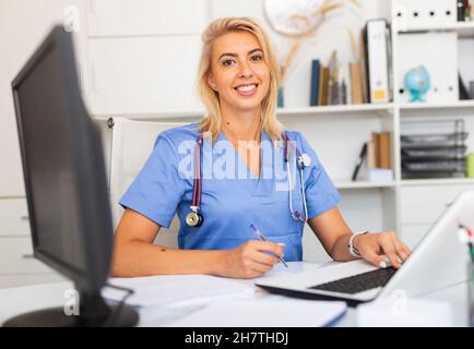 Porträt einer Ärztin, die in der Klinik mit einem Laptop arbeitet Stockfoto