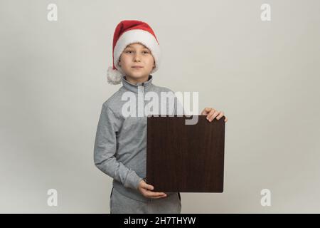 Der Helfer des Weihnachtsmannes hält ein quadratisches Brett für die Werbung Stockfoto