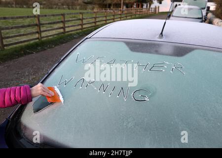 Teesdale, County Durham, Großbritannien. 25th. November 2021. Wetter in Großbritannien. Mit einer gelben Wetterwarnung vor starken Winden und Schnee für die meisten UK am Samstag räumt eine Frau Eis von ihrer Windschutzscheibe heute Morgen. Kredit: David Forster/Alamy Live Nachrichten Stockfoto