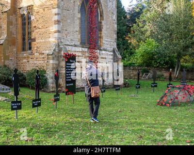 Ausstellung von Mohnblumen und Figuren-Silhouetten für den Remembrance Sunday, Church of St. Peter and St. Paul, Northampton, Großbritannien Stockfoto