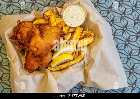 Kabeljaufilets, paniert und gebraten, mit Pommes frites, Senfsoße, Kapern, gehackten Gurken und Mayonnaise. Nordjütland, Dänemark Stockfoto