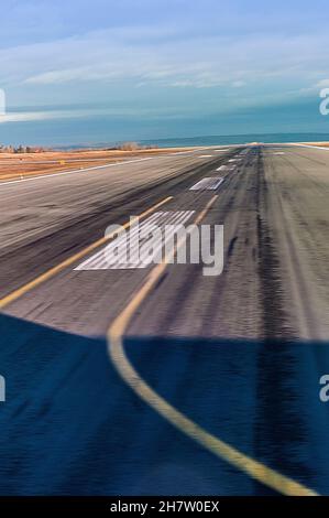 Eine Start- und Landebahn auf einem modernen internationalen Flughafen, Kanada. Blick aus dem Inneren eines abfliegenden Flugzeugs, das kurz vor der Abflugsbahn steht. Alltägliche Szene. Stockfoto