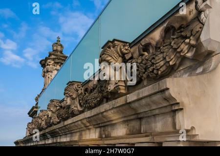 Schöne Nahaufnahme der skulpturierten Köpfe an der Fassade des Reichstagsgebäudes in Berlin. Die Sandsteinschnitzereien befinden sich auf dem Dach unter dem... Stockfoto