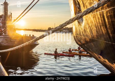 Rostock: Stadthafen, Museumsschiff-Eisbrecher 'Stephan Jantzen' (rechts), Gruppe Paddler zwischen großen Schiffen, Sonnenuntergang in Ostsee Stockfoto