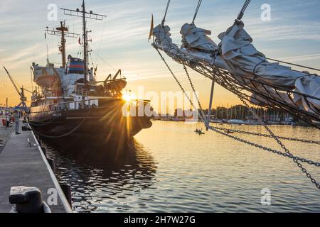 Rostock: Stadthafen, Museumsschiff-Eisbrecher 'Stephan Jantzen' (links), Segelschiff, Gruppe Paddler zwischen großen Schiffen, Sonnenuntergang am Ostsee ( Stockfoto