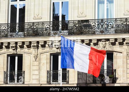 Die französische Flagge hing am Mietshaus und winkte im Wind. Stockfoto