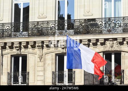 Die französische Flagge hing am Mietshaus und winkte im Wind. Stockfoto