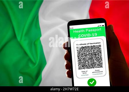 Am 24. November 20 wird in Barcelona, Spanien, ein Covid-Pass oder ein Green Pass auf dem Bildschirm eines Mobiltelefons mit der italienischen Flagge im Hintergrund angezeigt Stockfoto