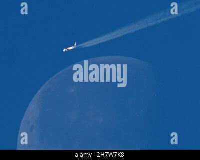 Sheerness, Kent, Großbritannien. 25th. November 2021. Ein Emirates Airbus A380 (Registrierung A6-EVQ), der von Dubai nach London Heathrow flog, flog heute Morgen um 11:16am Uhr direkt über dem unterschwellenden, schwindelerregenden Mond in einem sonnigen, blauen Himmel über Sheerness in Kent. Kredit: James Bell/Alamy Live Nachrichten Stockfoto