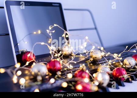 Eine bunte Kette von Lichtern liegt auf den Klaviertasten Stockfoto