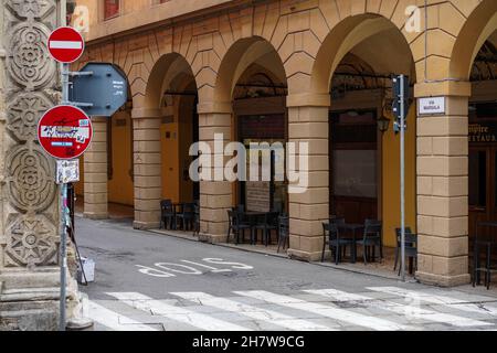 Restaurant ohne Kunden in Bologna während der Corona-Pandemie. Leere Tische und Stühle auf dem Bürgersteig in der Arkade davor. Stockfoto