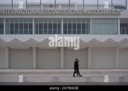 Zwei Spaziergänger passieren den Palazzo del Cinema auf Lido, Insel. Veranstaltungsort des Filmfestivals Mostra internazionale d’arte cinematografica di Venezia.