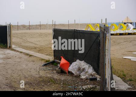 Blick auf den Sandstrand am Lido im November. Im Hintergrund Kinderrutschen zusammengestellt. Stockfoto