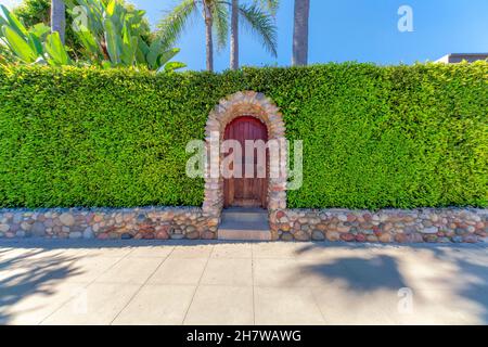 Gewölbte Holztür mit Steinmauern und Eingang in La Jolla, Kalifornien Stockfoto