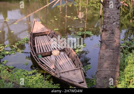 Im kleinen Kanal des tiefen Dorfes werden Boote an Palmen gebunden Stockfoto