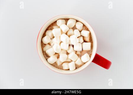 Draufsicht auf roten Becher mit heißer Schokolade und Mini-Marshallows isoliert auf weiß. Stockfoto