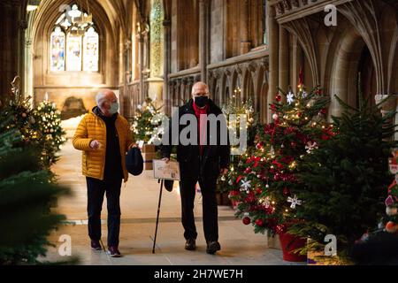 Die Besucher kommen vorbei, während die letzten Feinheiten vor der Eröffnung des berühmten Weihnachtsbaumfestivals in der Lichfield Cathedral in Staffordshire gemacht werden. Die Kathedrale wird mit 45 Weihnachtsbäumen geschmückt, von Wohltätigkeitsorganisationen, Gemeindeorganisationen, Schulen und Unternehmen geschmückt und gesponsert und wird an diesem Wochenende eröffnet. Bilddatum: Donnerstag, 25. November 2021. Stockfoto