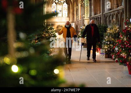 Die Besucher kommen vorbei, während die letzten Feinheiten vor der Eröffnung des berühmten Weihnachtsbaumfestivals in der Lichfield Cathedral in Staffordshire gemacht werden. Die Kathedrale wird mit 45 Weihnachtsbäumen geschmückt, von Wohltätigkeitsorganisationen, Gemeindeorganisationen, Schulen und Unternehmen geschmückt und gesponsert und wird an diesem Wochenende eröffnet. Bilddatum: Donnerstag, 25. November 2021. Stockfoto