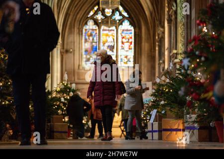 Die Besucher kommen vorbei, während die letzten Feinheiten vor der Eröffnung des berühmten Weihnachtsbaumfestivals in der Lichfield Cathedral in Staffordshire gemacht werden. Die Kathedrale wird mit 45 Weihnachtsbäumen geschmückt, von Wohltätigkeitsorganisationen, Gemeindeorganisationen, Schulen und Unternehmen geschmückt und gesponsert und wird an diesem Wochenende eröffnet. Bilddatum: Donnerstag, 25. November 2021. Stockfoto