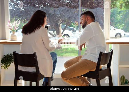 Treffen in einem Café. Vorstellungsgespräch. Pärchen unterhalten sich im Café. Frau ein Mann in einem Café. Stockfoto