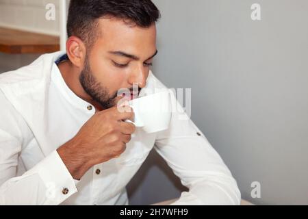 Mann trinkt Kaffee. Junge im Café. Junge mit Kaffee. Lifestyle. Junge, der sich im Café ausruht. Stockfoto