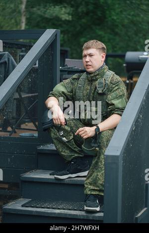 Voll ausgestattete Militärangehörige mit automatischen Waffen, die sich bereit machen, Airsoft-Strikeball zu spielen Stockfoto