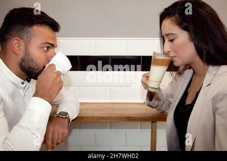 Ein Paar, das Kaffee getrunken hat. Ein Paar im Café. Junge und Mädchen mit Kaffee. Termin. Arbeitspause. Entspannter Mann und Frau beim Kaffee. Stockfoto