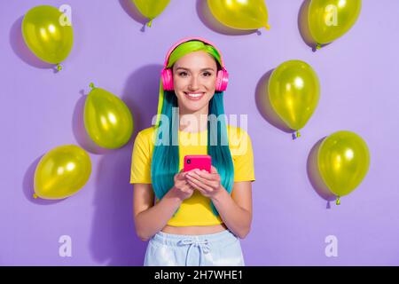 Portrait von schönen trendigen fröhlichen Mädchen mit Gerät hören Hit Pop Melodie isoliert über violett lila Farbe Hintergrund Stockfoto