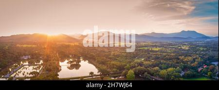 Luftaufnahme von Berg und Baum mit dramatischem Himmel bei Sonnenuntergang Stockfoto