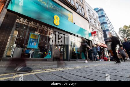 The EE Store, Oxford Street, London. Einkäufer, die am britischen Mobiltelefon- und Telekommunikationsgeschäft im geschäftigen Londoner Einkaufsviertel vorbeikommen. Stockfoto