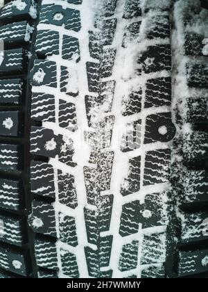Winterreifen mit Spikes für Offroad-Fahrzeuge. Vertikales Foto. Stockfoto