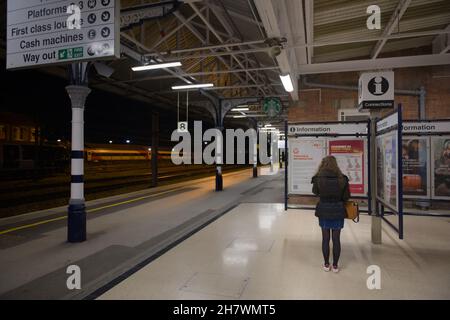 Doncaster, Großbritannien, 22nd. Mai 2021: Weitwinkelaufnahme des bahnhofs doncaster, Bahnsteig 8 in der Nacht. Frau liest Informationspunkt. Stockfoto