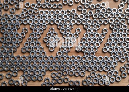 Das neue Jahr 2022 ist lässig mit Metallnüssen auf einem Holztisch ausgekleidet. Draufsicht. Stockfoto