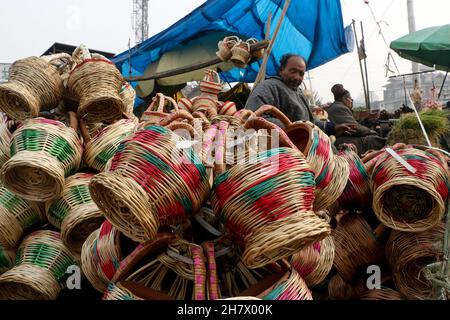 Srinagar, Indien. 24th. November 2021. Ein Kashmiri-Mann verkauft am 24. November 2021 auf einem Markt in Srinagar, Kaschmir, Indien, einen traditionellen Feuertopf Kangri. Zweige werden über einen irdenen Tontopf gewebt, um einen Kangri zu bilden. Die kangri ist mit brennender Kohle gefüllt, um die Menschen den ganzen Winter über warm zu halten. (Foto von Kamran Raashid Bhat/INA Photo Agency/Sipa USA) Quelle: SIPA USA/Alamy Live News Stockfoto