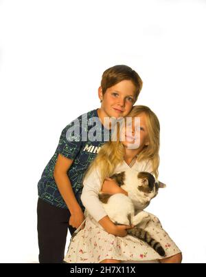 Ein Bruder und eine Schwester halten ihre Katze Stockfoto