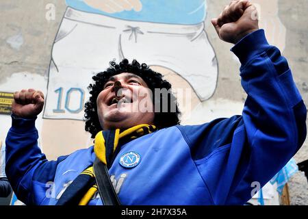 Napoli, Italien. 25th. November 2021. Ein Boca Juniors Fan mit einer Zigarre im Mund feiert am Wandgemälde von Diego Armando Maradona im Spanischen Viertel zum Jahrestag des ersten Jahres seit seinem Tod. Napoli, Italien, 25. November 2021. (Foto von Vincenzo Izzo/Sipa USA) Quelle: SIPA USA/Alamy Live News Stockfoto