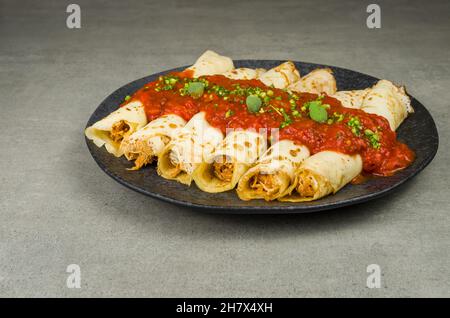 Brasilianische Pfannkuchen mit Huhn, Tomatenbolognese-Sauce, gerollte Pfannkuchen. Stockfoto