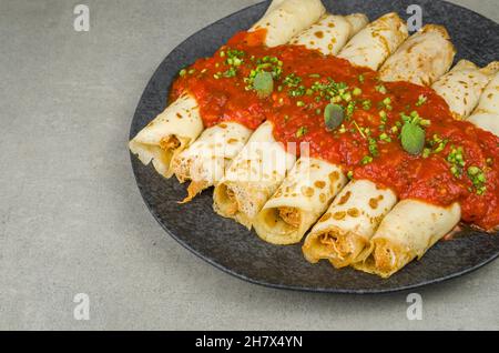 Brasilianische Pfannkuchen mit Huhn, Tomatenbolognese-Sauce, gerollte Pfannkuchen. Stockfoto