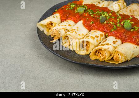 Brasilianische Pfannkuchen mit Huhn, Tomatenbolognese-Sauce, gerollte Pfannkuchen. Stockfoto