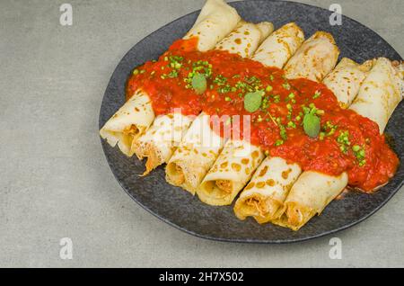 Brasilianische Pfannkuchen mit Huhn, Tomatenbolognese-Sauce, gerollte Pfannkuchen. Stockfoto