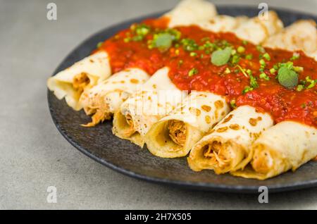 Brasilianische Pfannkuchen mit Huhn, Tomatenbolognese-Sauce, gerollte Pfannkuchen. Stockfoto