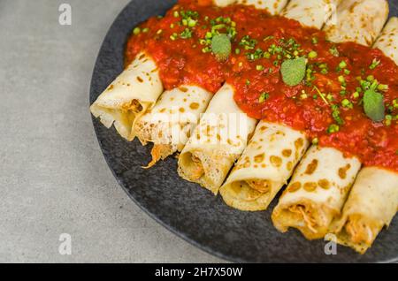 Brasilianische Pfannkuchen mit Huhn, Tomatenbolognese-Sauce, gerollte Pfannkuchen. Stockfoto