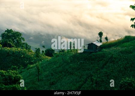 Bild des Bandarban-Hügeltraktes, Bangladesch. Natürliche Hügellandschaft mit Wolken. Haus auf der Spitze eines Berges. Stockfoto